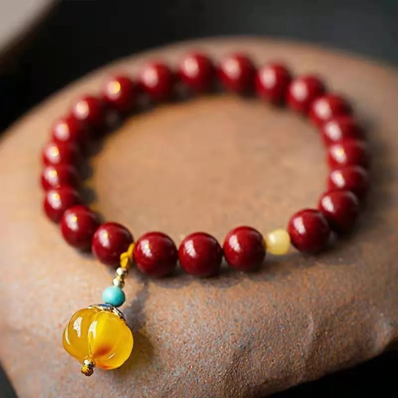 Handcrafted Chinese cinnabar bracelet with gold copper beads in wave design on wrist