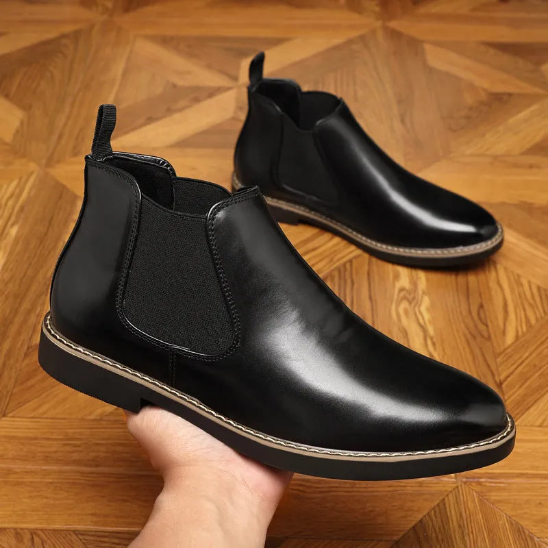 Black formal pointed-toe leather boots with a square heel and rubber sole on a neutral background.