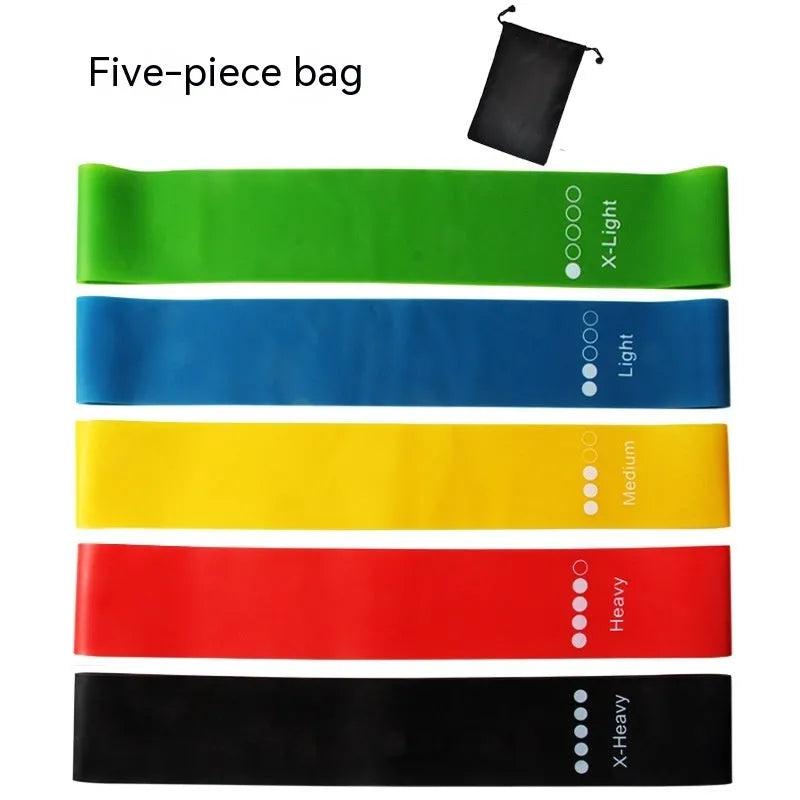 Set of five coloured yoga resistance bands with force markings arranged by thickness from thinnest to thickest
