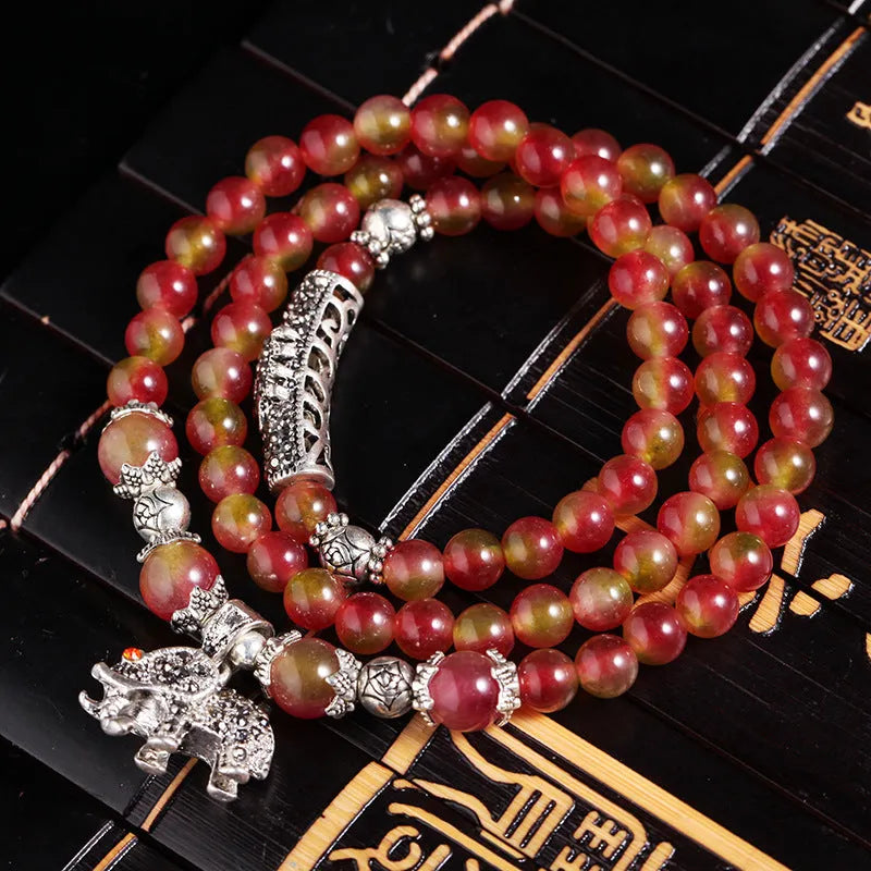 Handmade natural watermelon crystal bracelet with Chinese knots, shown in geometric national style.