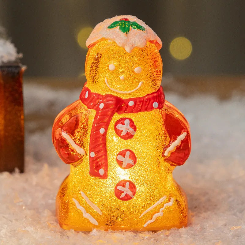 Glowing red-scarf gingerbread man Christmas ornament with modern design on a green tree branch.