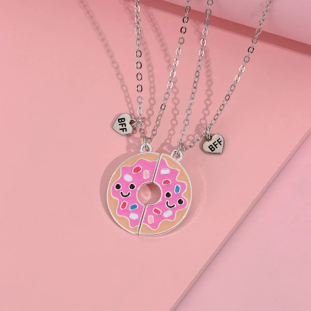 Two matching zinc alloy pendants in donut and watermelon shapes with glossy oil drip finish on cross chains