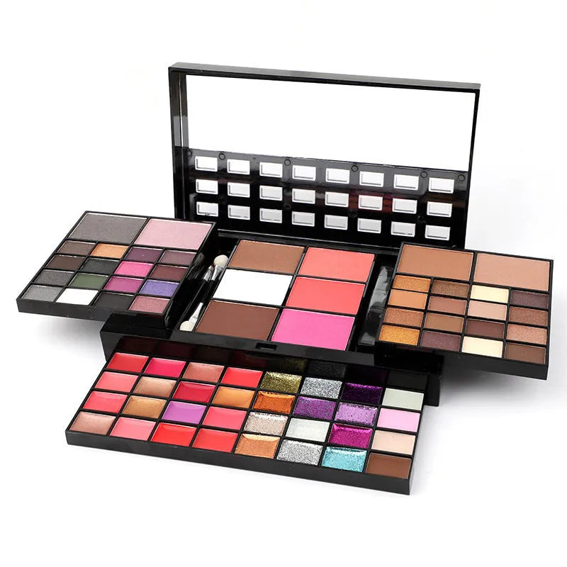 Open 74-colour makeup palette showing four layers of eyeshadow, lip gloss, blush, and contour powders with included brushes.