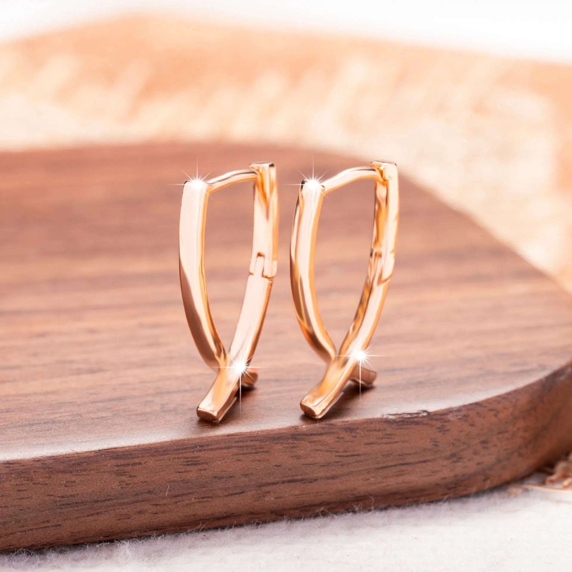 Rose gold coloured cross shaped earrings on a copper base.