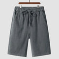 Men's beige linen casual shorts with loose cropped fit and elastic waistband on a neutral background.