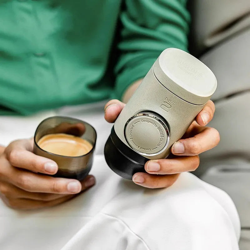 Olive gray manual espresso portable capsule coffee machine with storage bag and accessories on outdoor table