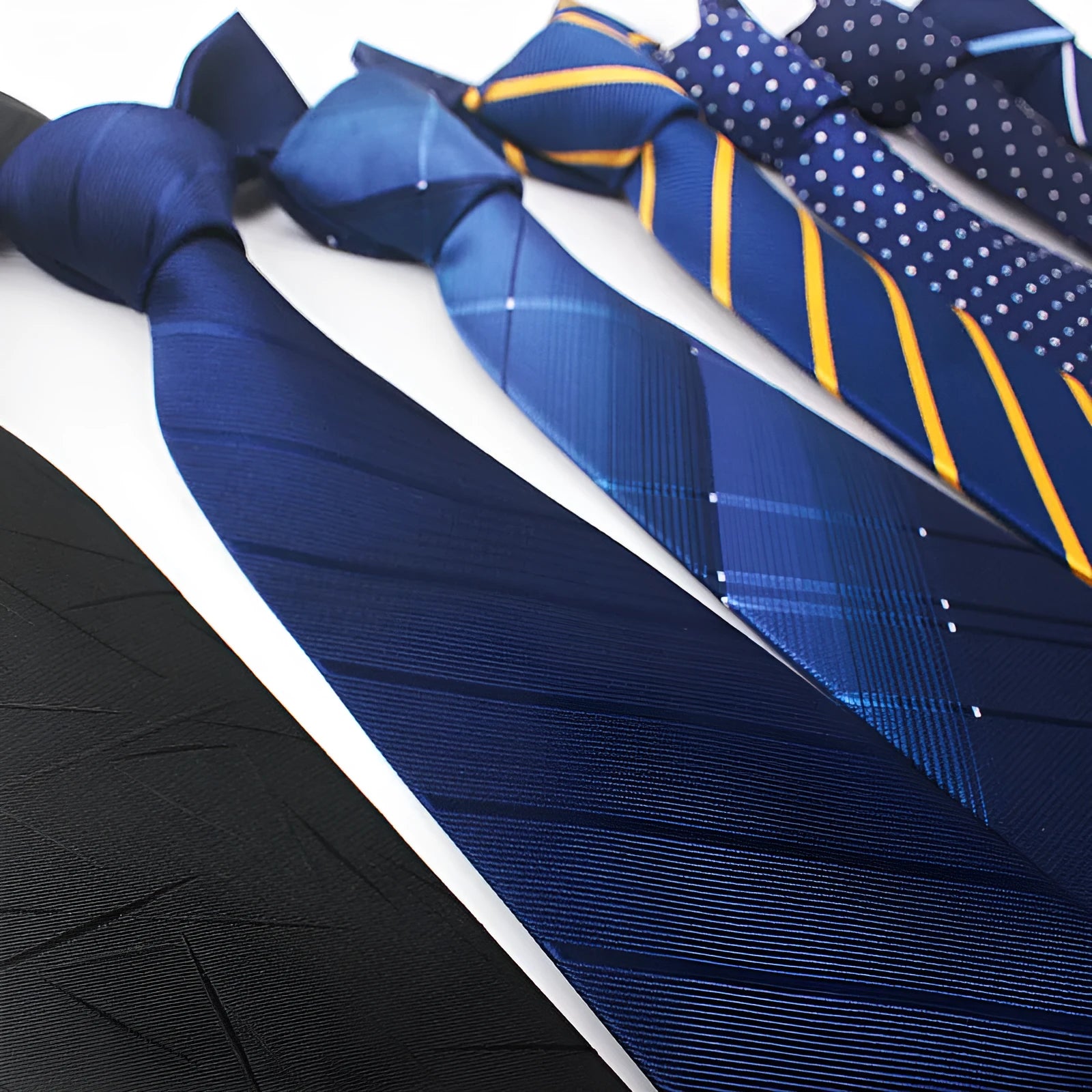 Close-up of a man's striped jacquard woven tie in a classic arrow shape, showing textured fabric detail.