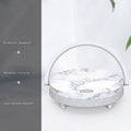 Wireless charging LED night light with Bluetooth speaker in marble pattern finish on a wooden table.