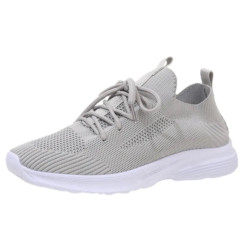 Women's low-top running shoes in Flyknit mesh, shown in creamy white colour with flat rubber sole.