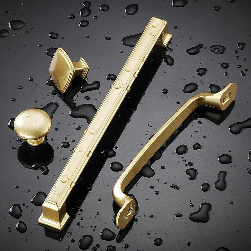 Gold coloured aluminium alloy T-shaped cabinet door handle showing single hole mounting.