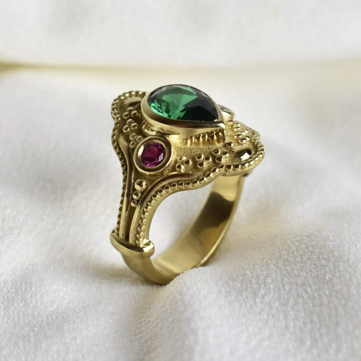 Women's geometric fashion ring in golden lvzuan colour on a grey background.