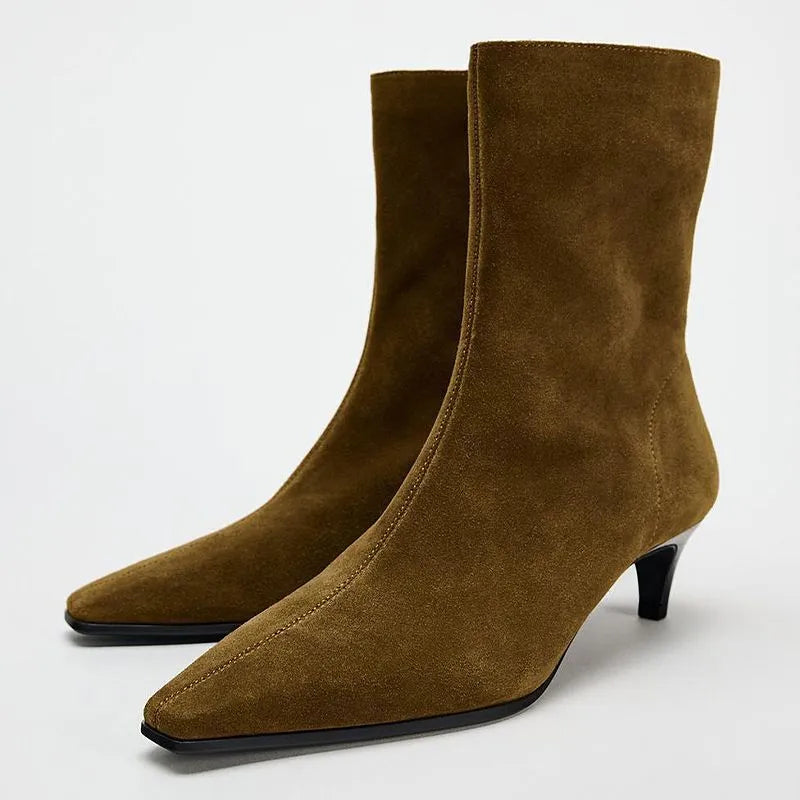 Brown women's square toe mid-calf boots with a side zipper and a low kitten heel on a wooden floor.