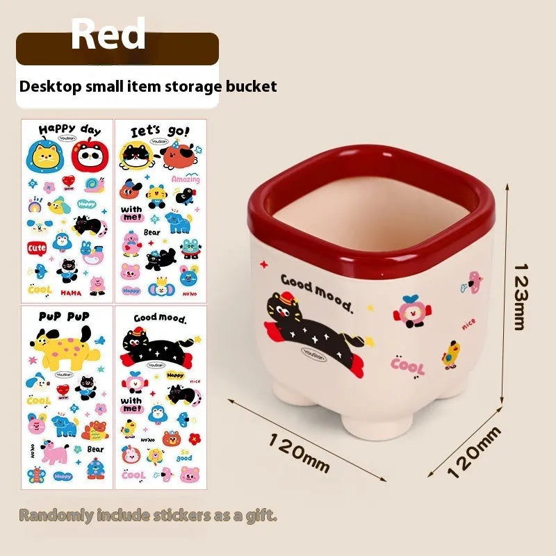 Red and brown cartoon sticker designs on a plastic desktop storage box with grid organiser compartments.
