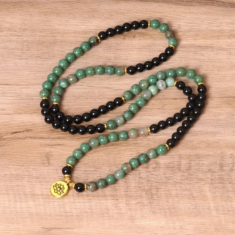 Green and black alloy elastic beaded bracelet on a wrist.