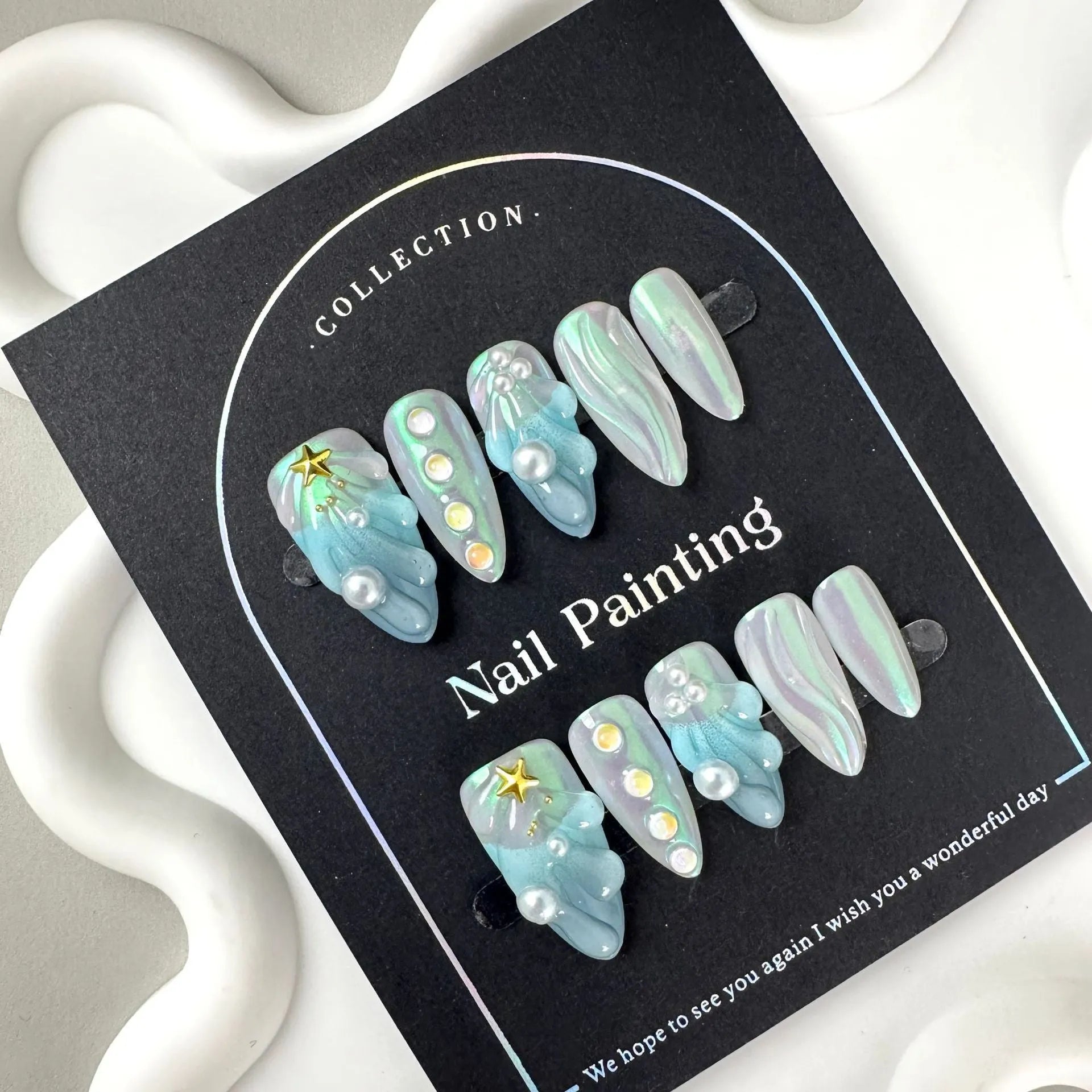 Blue plastic nail stickers and wearable nail armour pieces set on a white background.