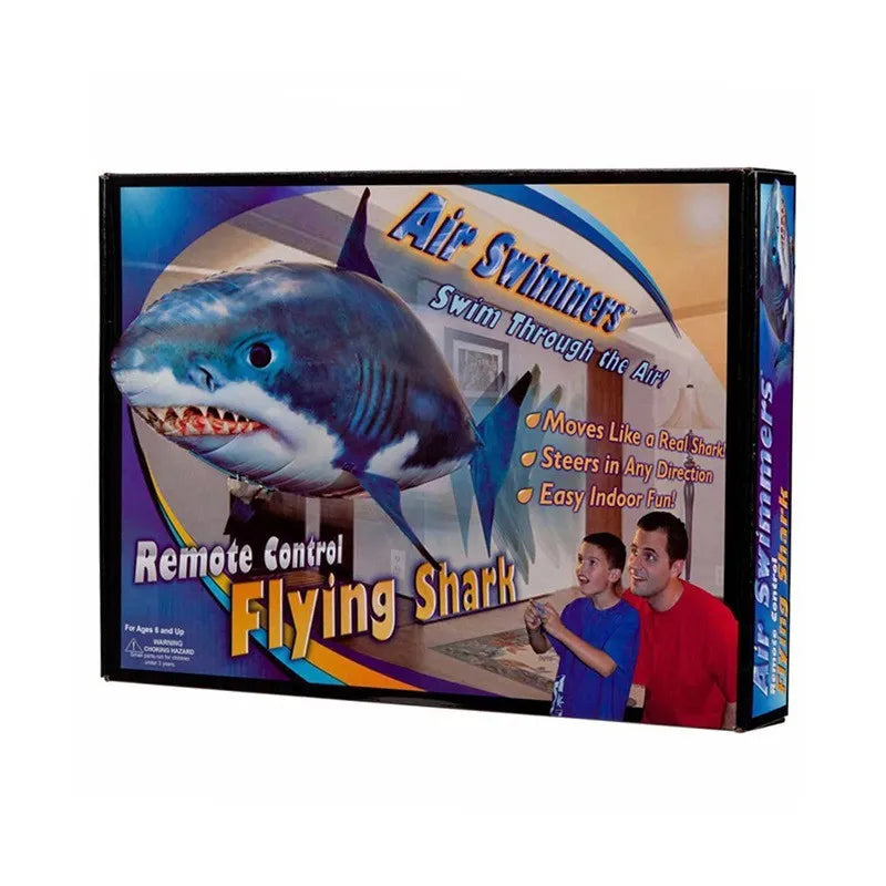 Large remote control shark-shaped helium balloon toy floating indoors with a remote.