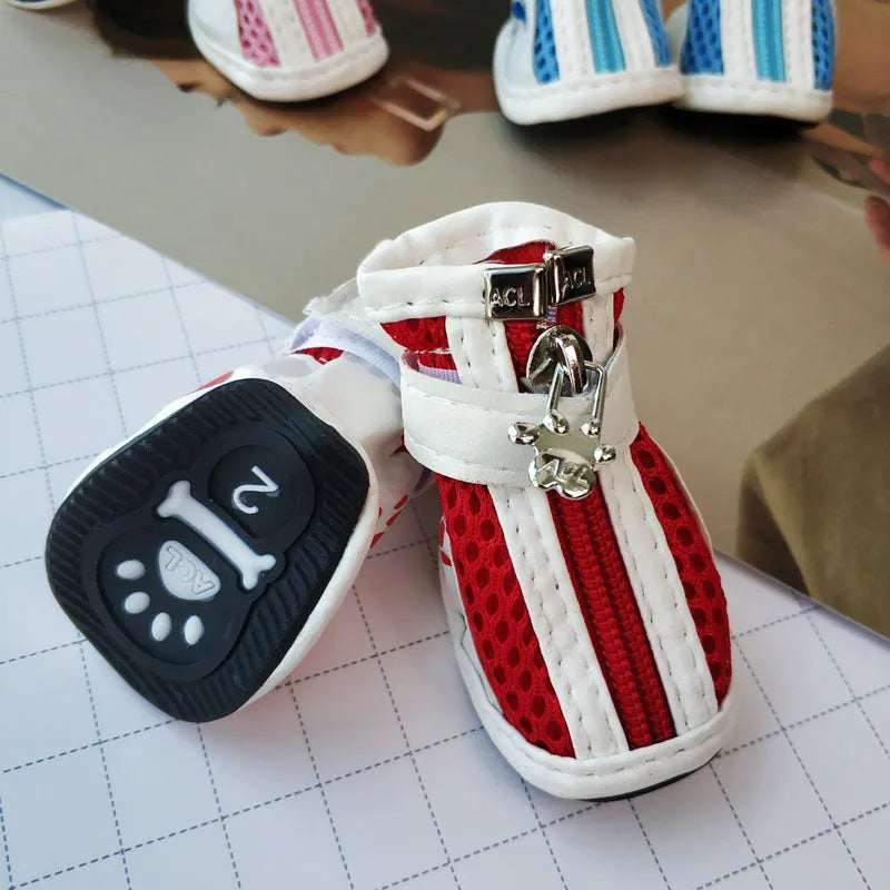Four blue cloth dog shoes with zipper closures and non-slip soles arranged together