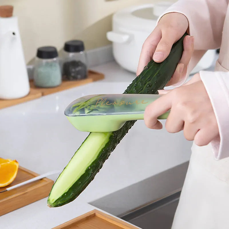 Dark green kitchen peeler with stainless steel blade stored in its tube, next to a potato.