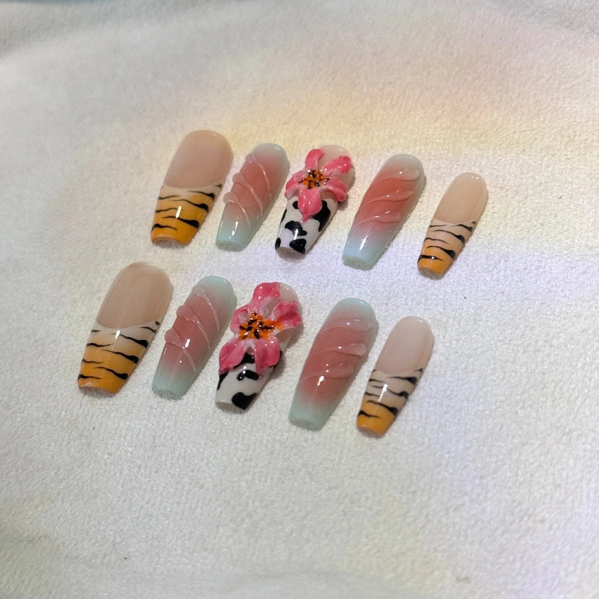 Embossed lily flower and leopard print zebra pattern nail art set showing dimensional texture and size variations
