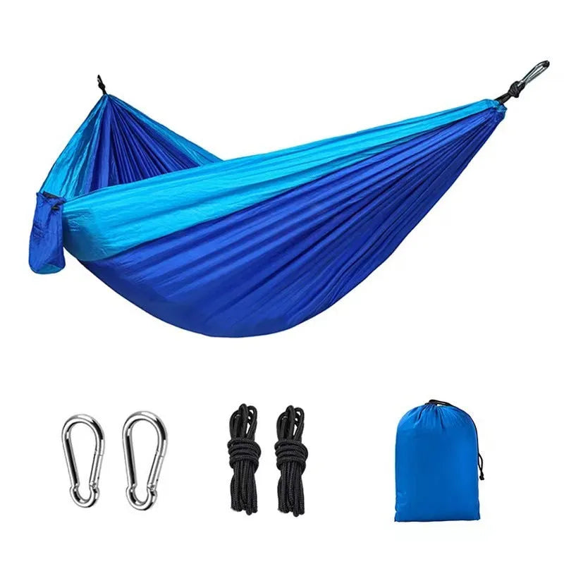 Blue parachute nylon outdoor camping hammock hung between two trees, showing its full 270 cm length.