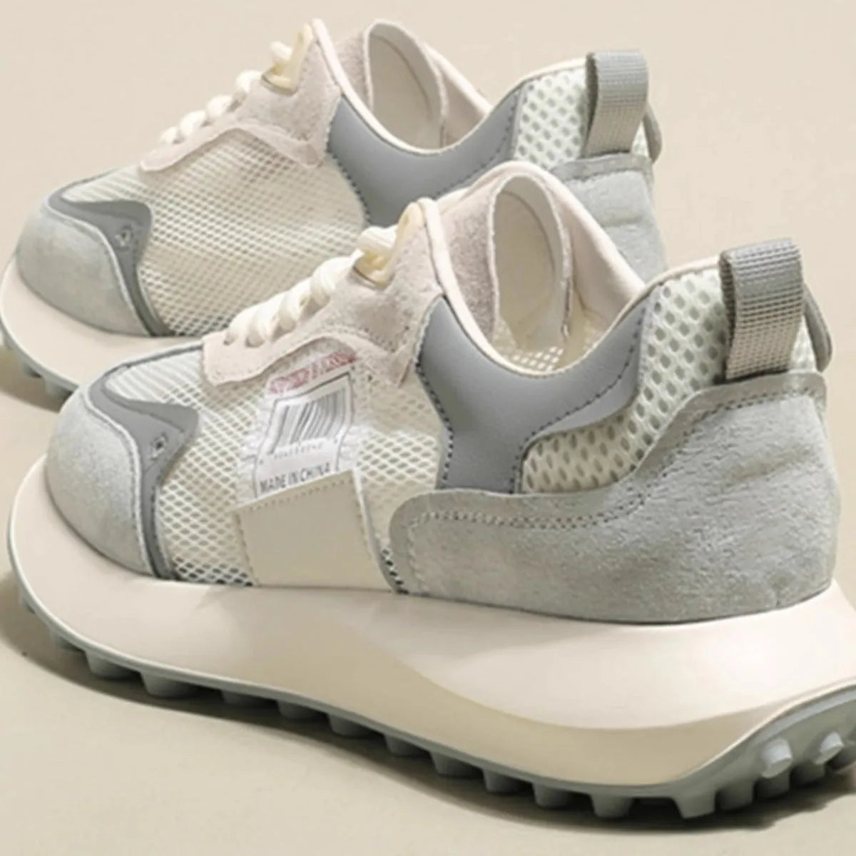 Women's gray and pink retro sneakers with mesh lining, rubber sole, and low-top design
