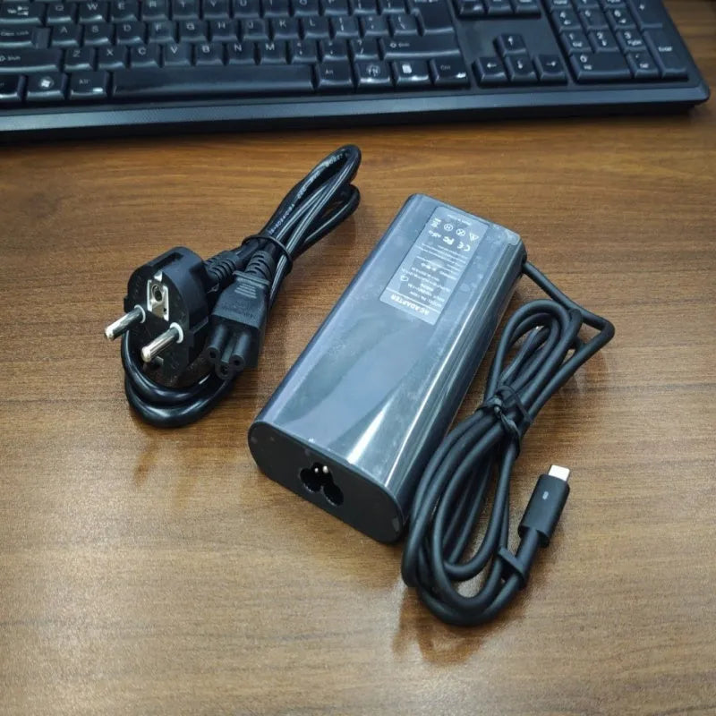 Black 65W Type-C laptop power adapter with six international power cords for worldwide charging