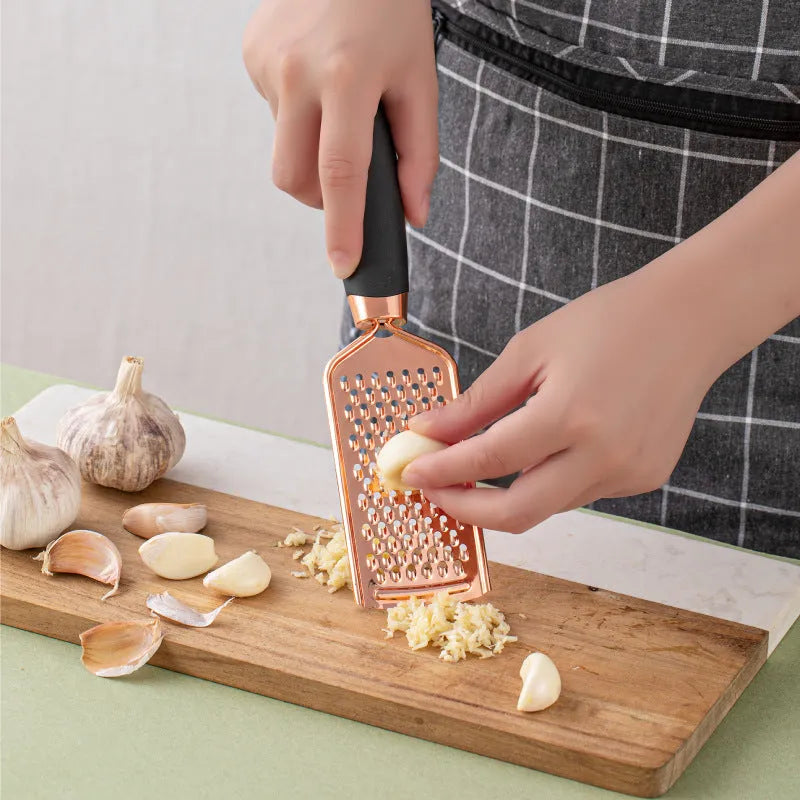 7-piece stainless steel kitchen tool set with copper plating peeler gadget in a cutlery rack on a countertop