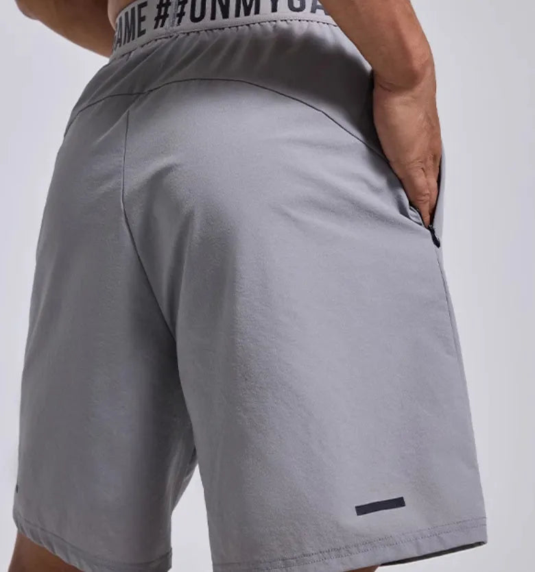 Men's loose cropped sports shorts in black with elastic waist and letter detail.