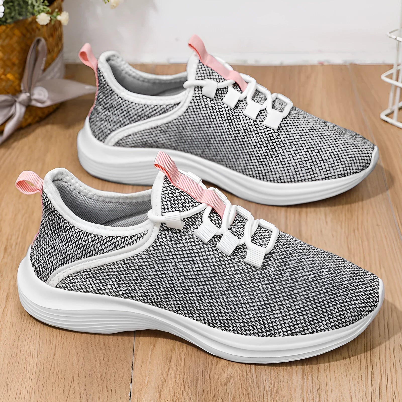 Women's low-top casual sneakers in black, pink or grey with breathable mesh upper and front lace-up fastening.