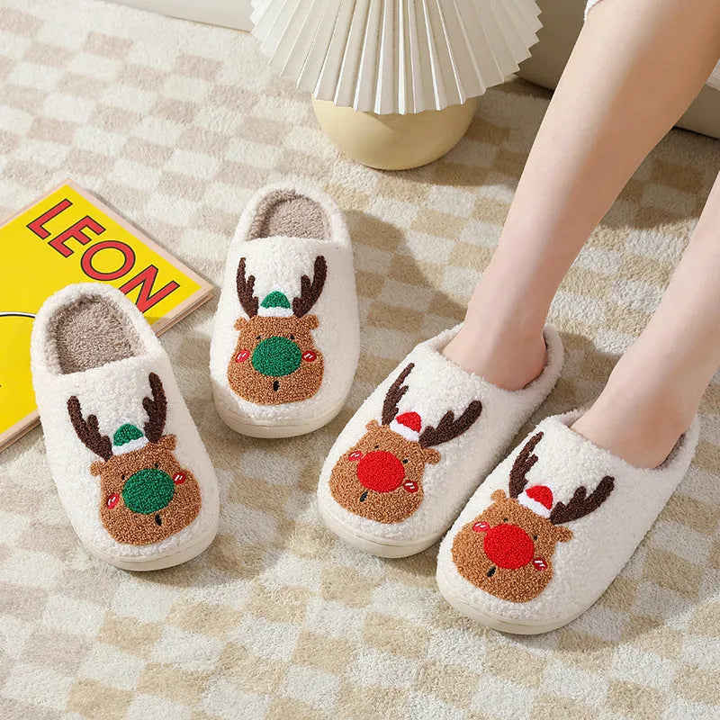 Pair of red Christmas elk plush home slippers on floor, soft anti-slip shoe design