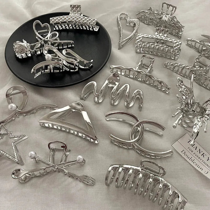 Electroplated silver metal hair barrettes in various designs including cross, wave, and bow shapes.