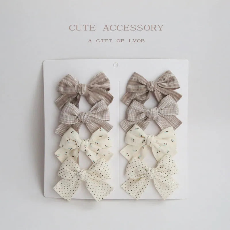 Set of children's fabric hairclips with dovetail bows in eight different colours and patterns.