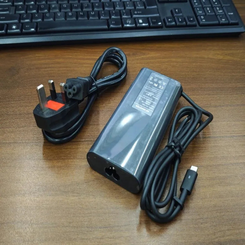 Black 65W Type-C laptop power adapter with six international power cords for worldwide charging