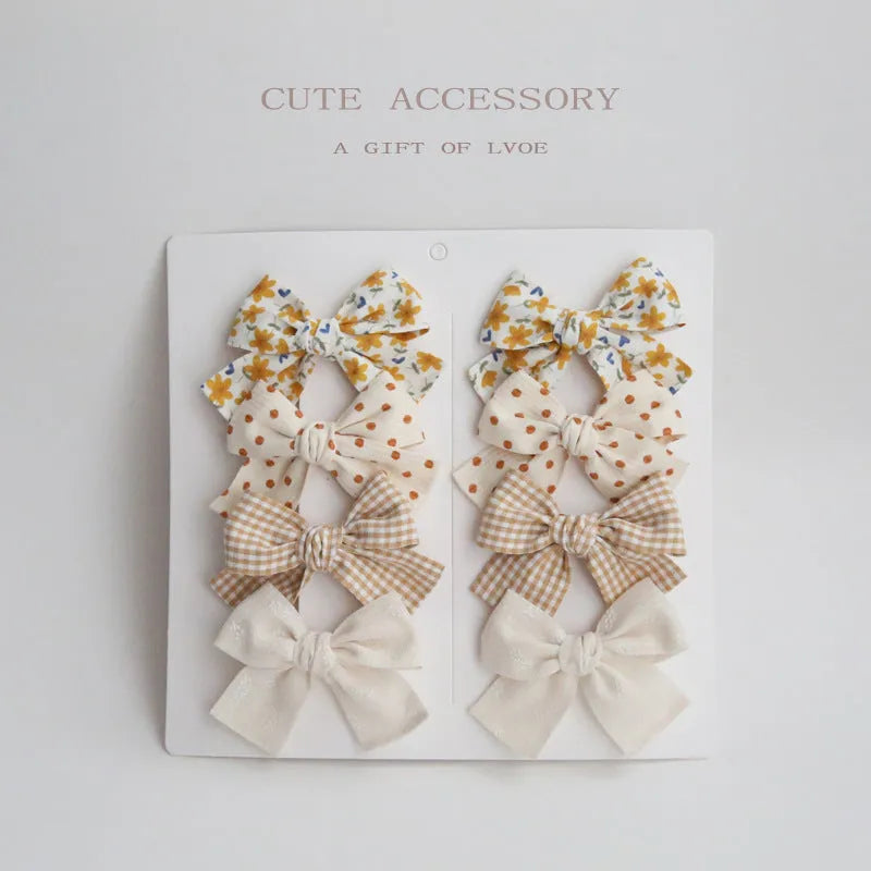 Set of children's fabric hairclips with dovetail bows in eight different colours and patterns.