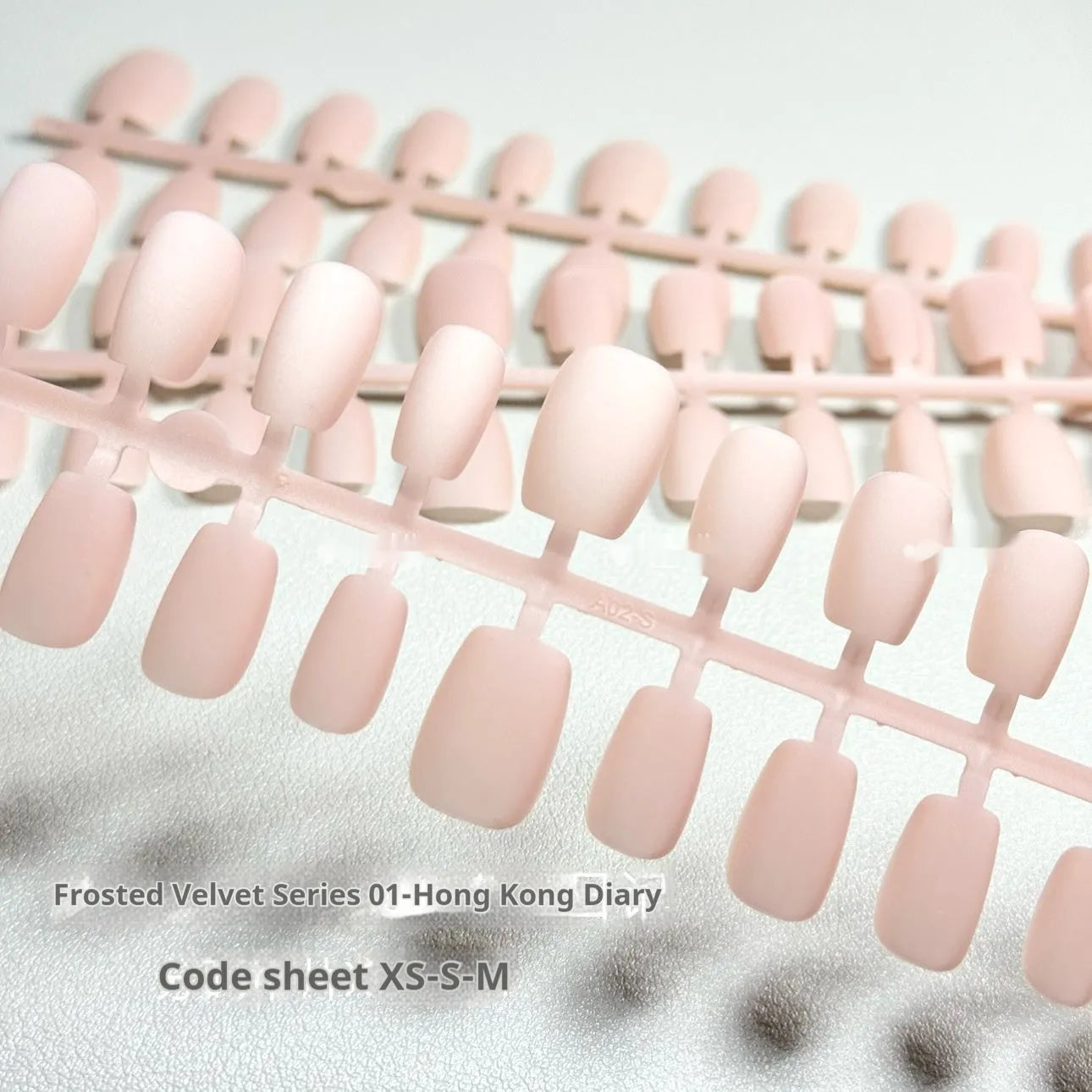 Set of frosted velvet Cat's Eye effect press-on artificial nails in short ladder shapes on a clear background.
