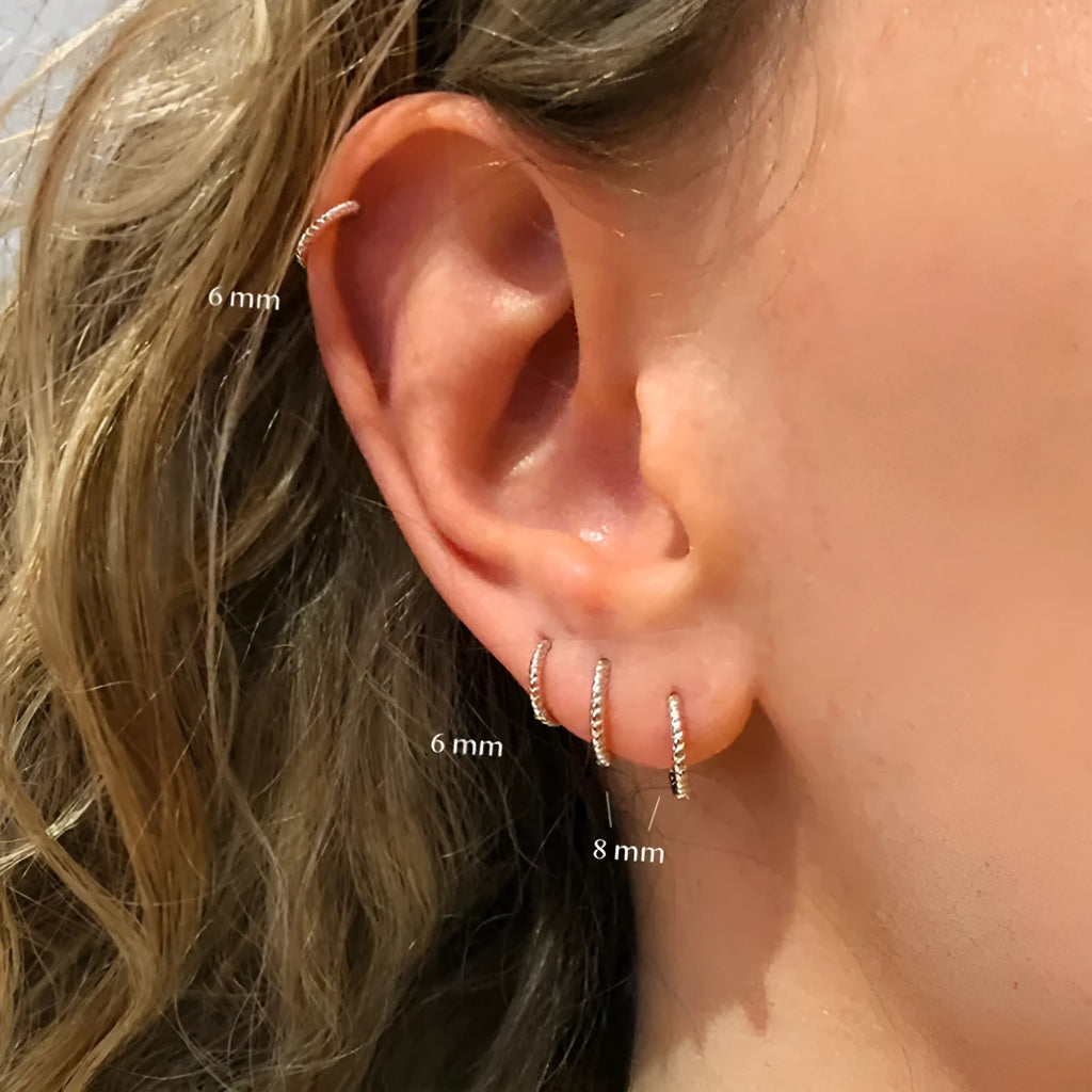 Close-up of S925 sterling silver twisted string round hoop earrings in gold finish.