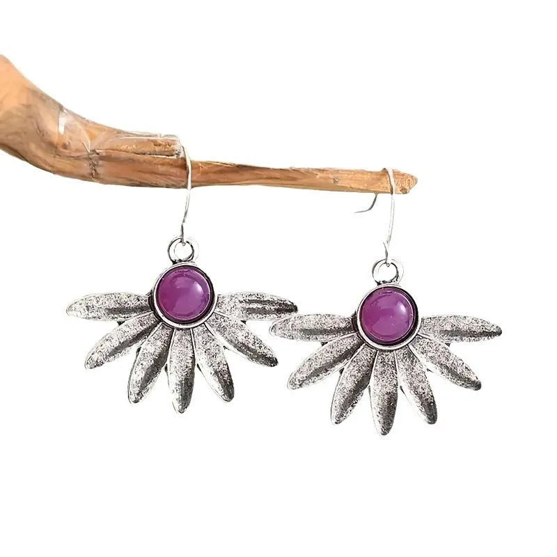 Close-up of purple bohemian drop earrings with animal zodiac design and resin gemstone details on alloy posts.