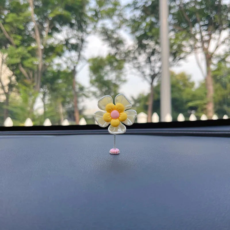 Blue plastic swing-shaped car decoration with a smiling face, hanging from a loop.