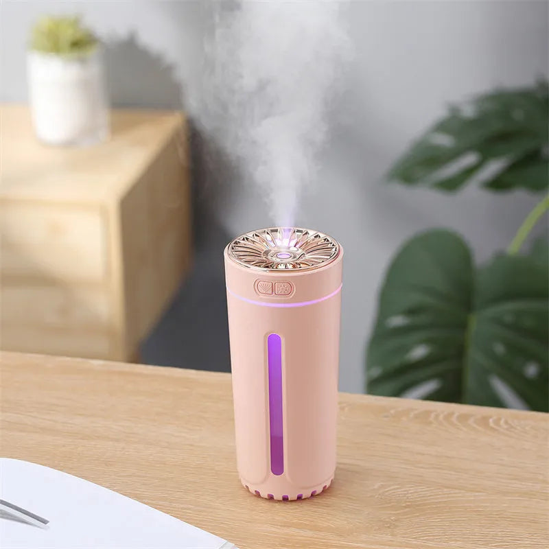 Black and white portable USB rechargeable humidifier with colourful LED lights on a car cup holder.
