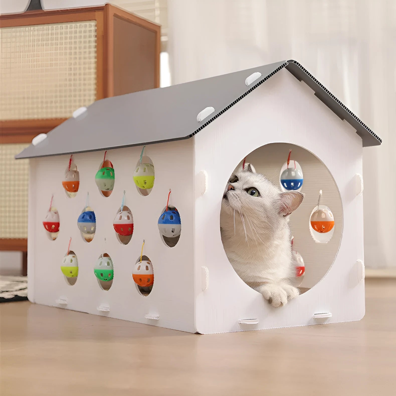 Integrated plastic cat scratch board with attached nest, tunnel, and a bell ball toy.