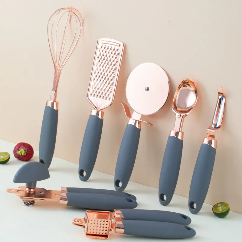 7-piece stainless steel kitchen tool set with copper plating peeler gadget in a cutlery rack on a countertop