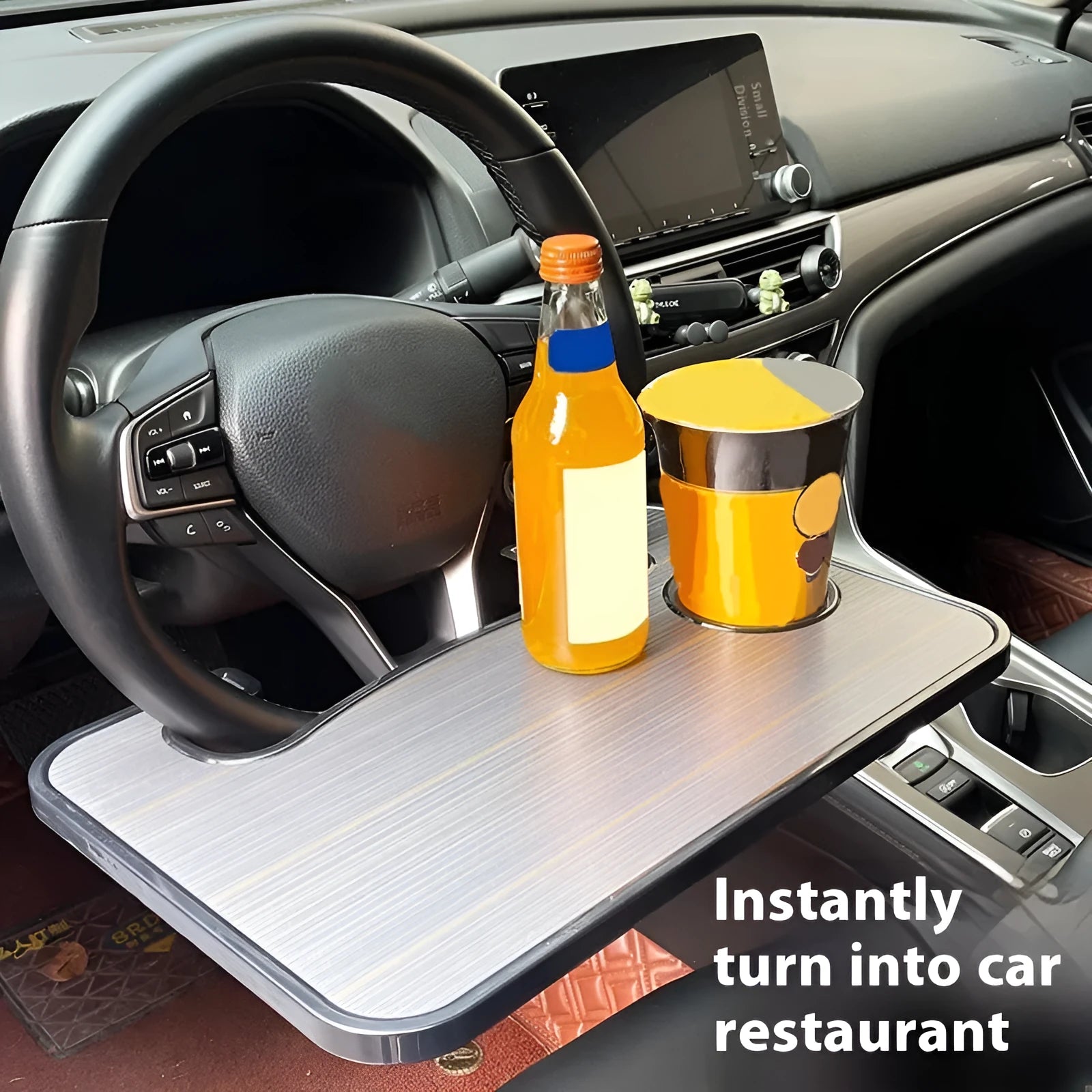 Foldable black car tray stand with cup holder on a car passenger seat