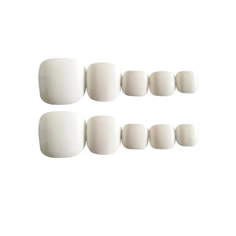 White false toe nails with a starry sky pattern, shown with a tube of nail glue.