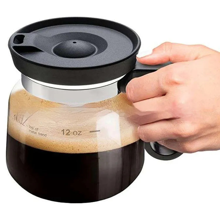Transparent borosilicate glass coffee jug with black silicone cover on a kitchen counter