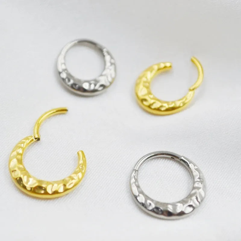 Titanium alloy concave-convex nose ring with carving detail in gold and silver anodised finishes.