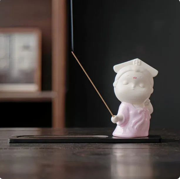 Ceramic cute female court attendant incense burner decoration in hand-painted colours on a shelf.