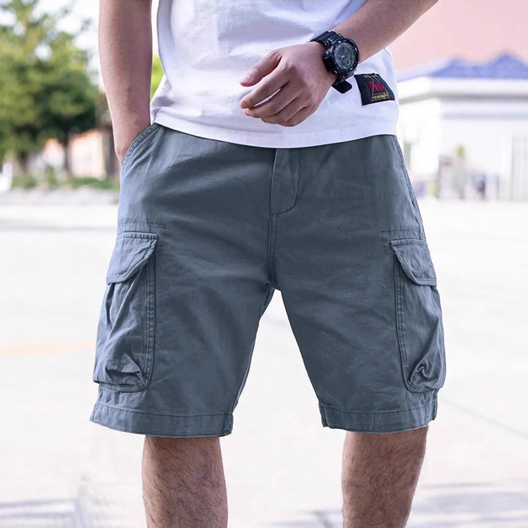 Man wearing loose-fitting army green cotton-blend retro workwear shorts for summer.