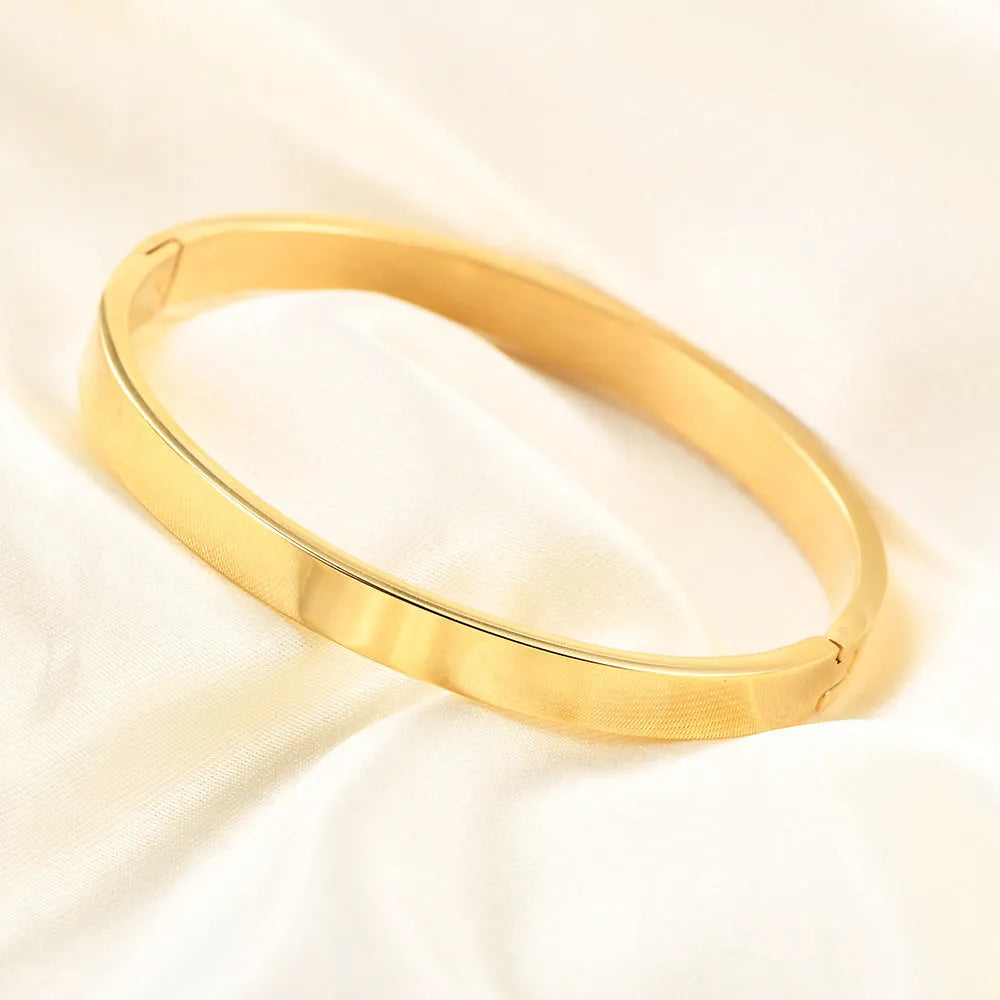 Polished stainless steel snap bracelet with oval links on plain background