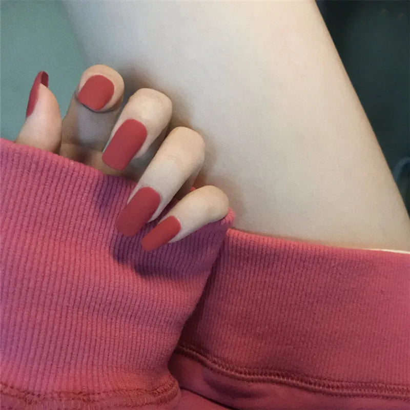 24 false nails in matte red medium length with glue adhesive in packaging
