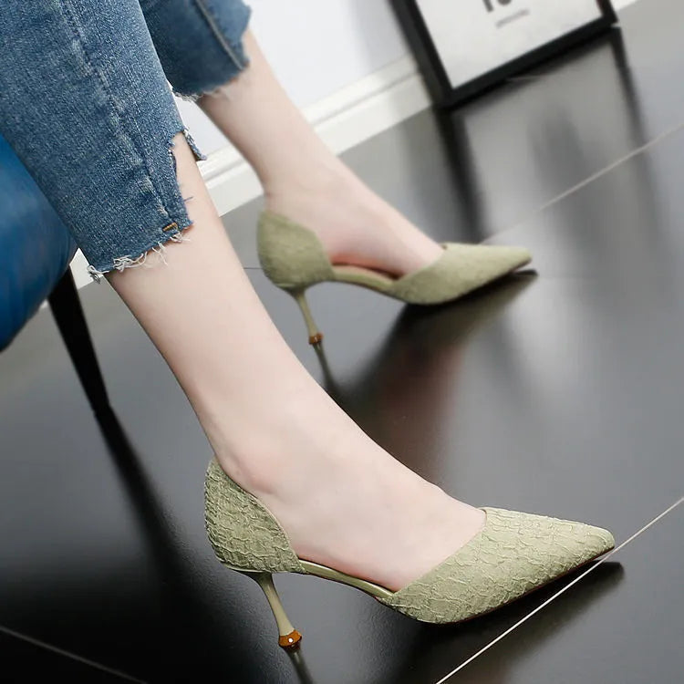 Women's black pointed stiletto heels with 6-8cm heel on wooden surface